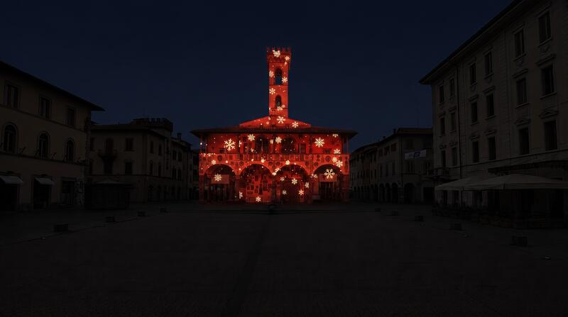Palazzo civico con torre illuminata in rosso e oro