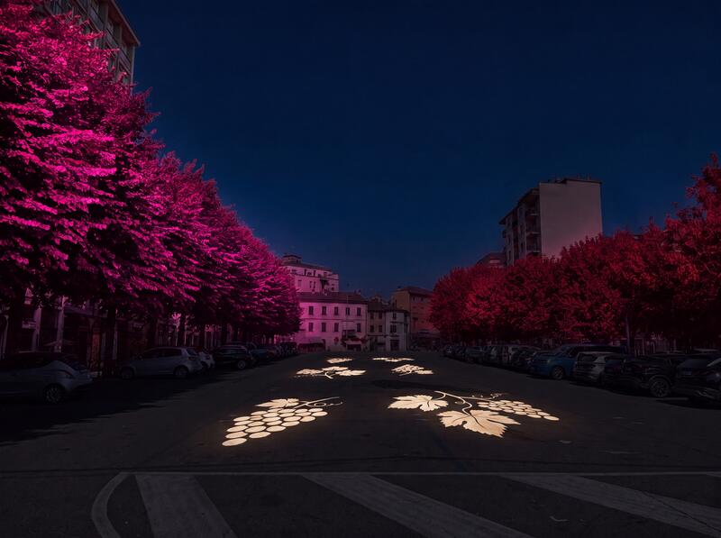 Via alberata con alberature illuminate in bicromia e proiezioni a terra